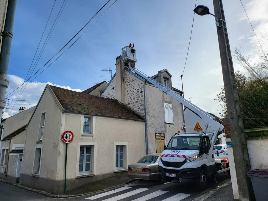 En intervention — Rue de village, camionnette de chantier stationnée