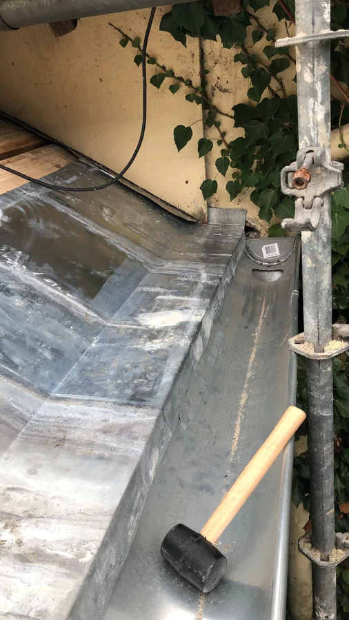 Zinguerie — Travail du zinc depuis l'échafaudage, maillet en main